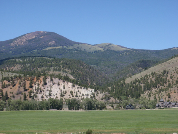 A view of a nice house across and nice field and Jerry Creek.